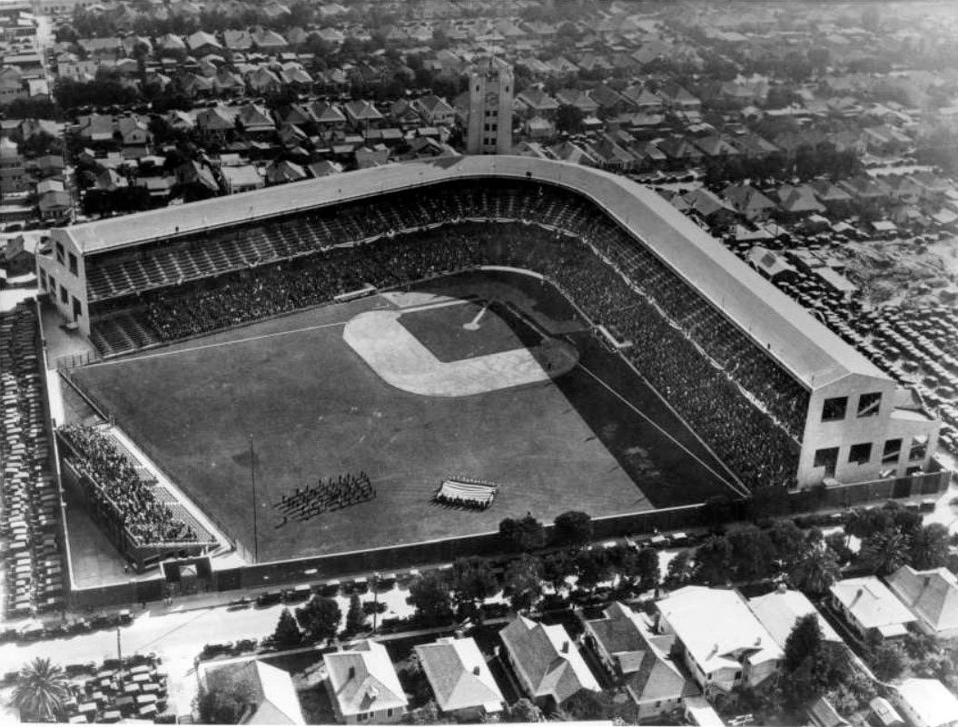 (ca. 1940)[^](http://digitallibrary.usc.edu/cdm/compoundobject/collection/p15799coll65/id/1322/rec/63) – Aerial view showing Wrigley Field at pre-game ceremony. An American flag being supported by four lines of people can be seen below the diamond. A group of people stand in rows to the left of the flag while the lower levels of the stadium are visibly full.