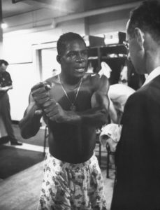 Minnie Minoso explains his hitting style to reporters post game in August of 1955.