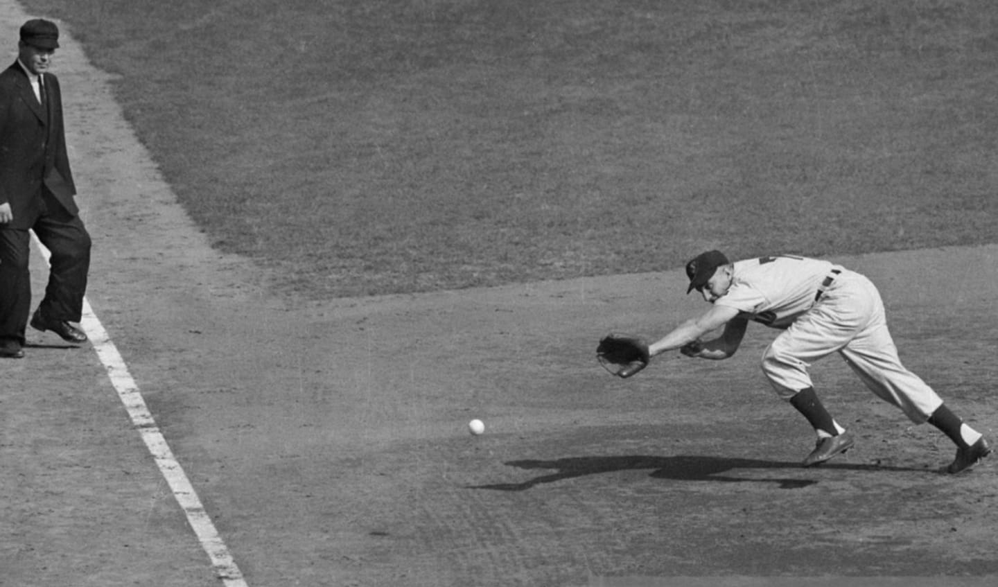 Al Rosen of the Cleveland Indians is doing a mighty stretch in an attempt to reach the ball as Wes Westrum