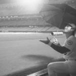 April 12, 1976: Los Angeles Dodgers first baseman Steve Garvey shields his head with an umbrella while watching rain fall at Dodger Stadium. After a 75-minute delay, the scheduled home opener was postponed. (Joe Kennedy / Los Angeles Times Archive/UCLA)