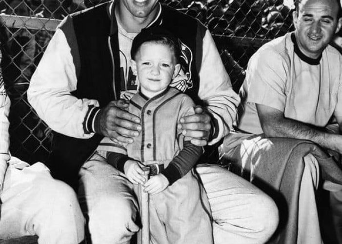 A child poses with Cleveland Indians pitcher Bob Feller at Burbank's Olive Memorial Stadium in 1949.